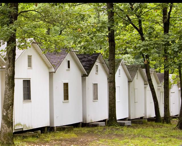 A row of white cabins in the trees
