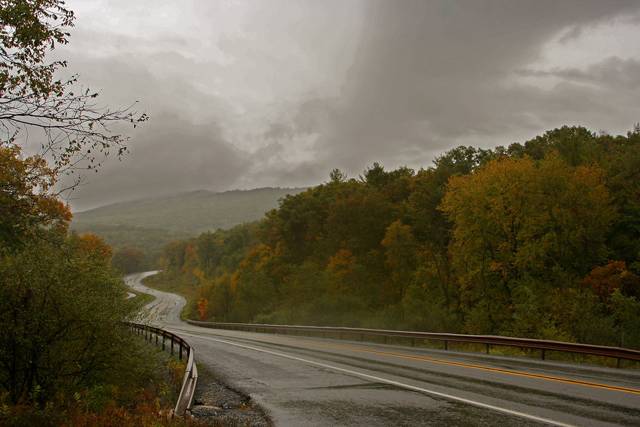 Autumn highway disappearing into rain